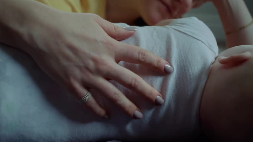 A mother caresses her son while he sleeps