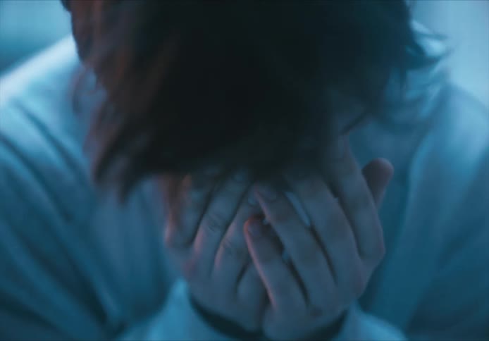 A person will be sad with their hands covering their face