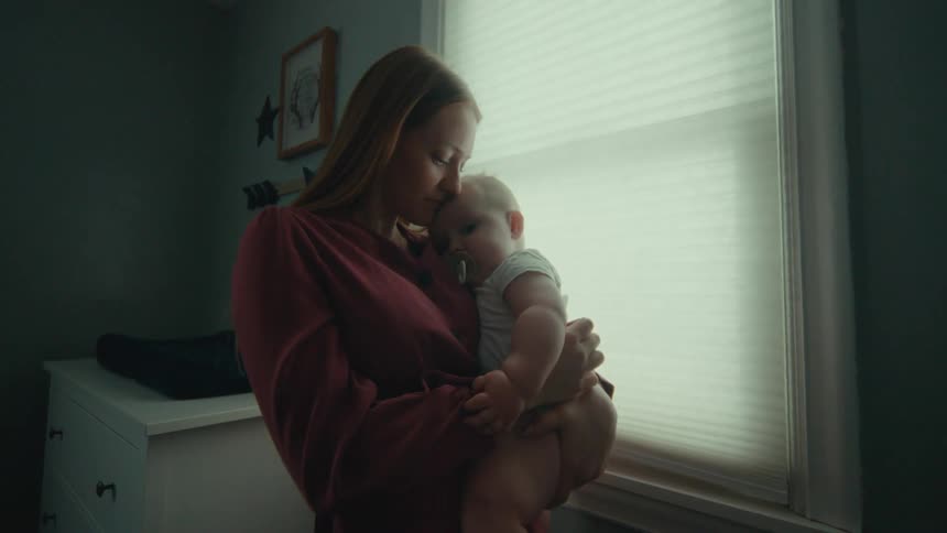 A mother tenderly holds her baby