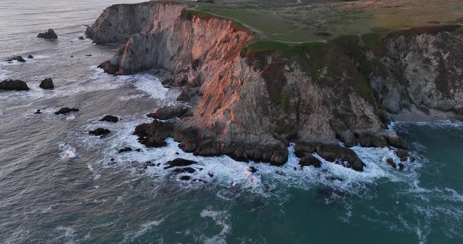The waves are crashing against the island cliffs