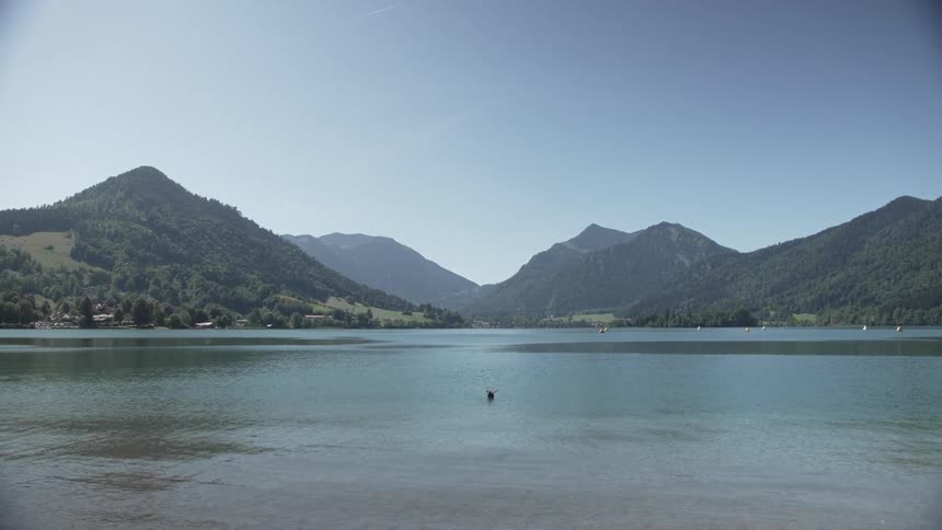 Landscape of a lake with mountain ranges around in the cloudless sky