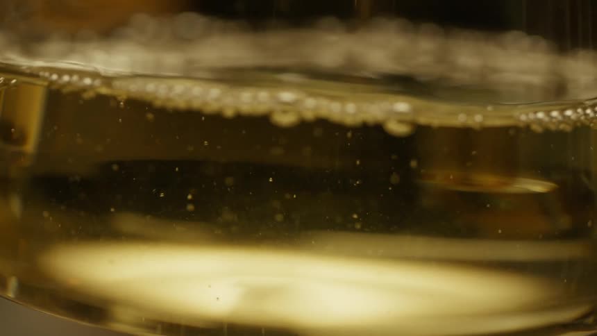 Wine pours into a glass and is picked up
