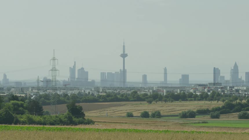 Landscape of a field with a metropolis in the background