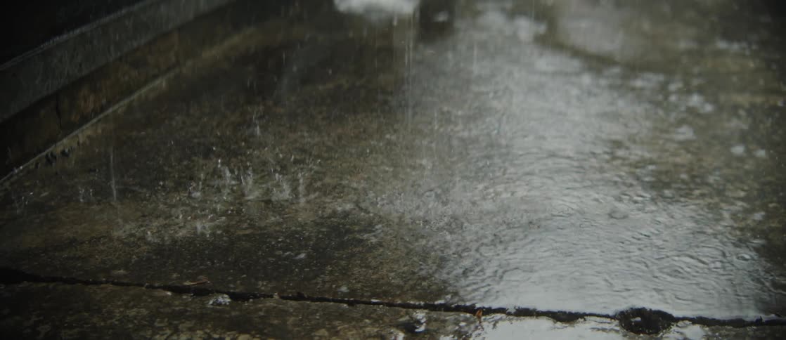 Drops of rain wetting the asphalt surface
