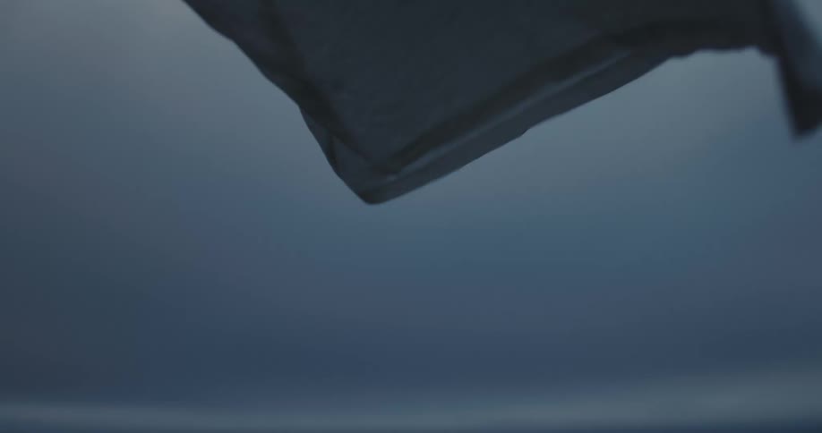 Closeup of a white tshirt flying in the wind in an open space on a cloudy day