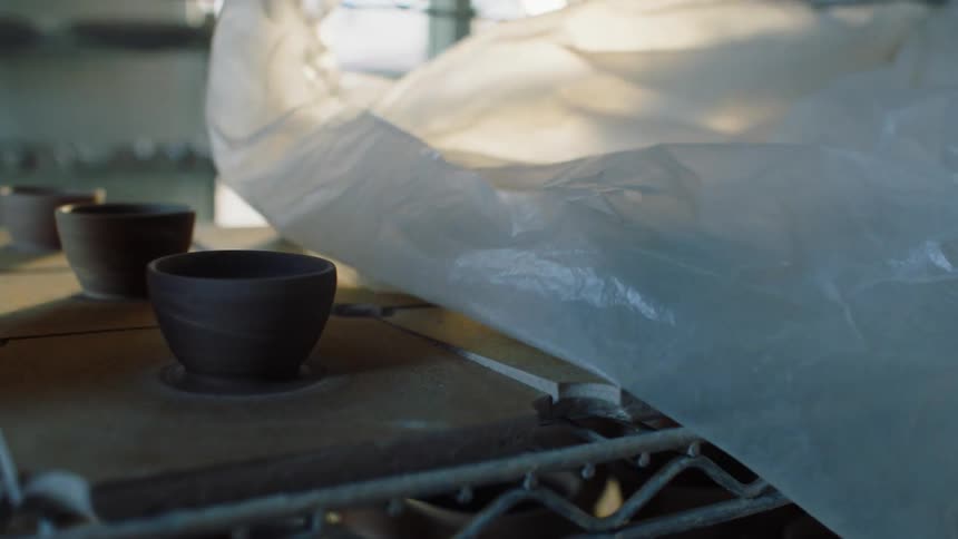 Woman removing a plastic bag from small handmade porcelain cups