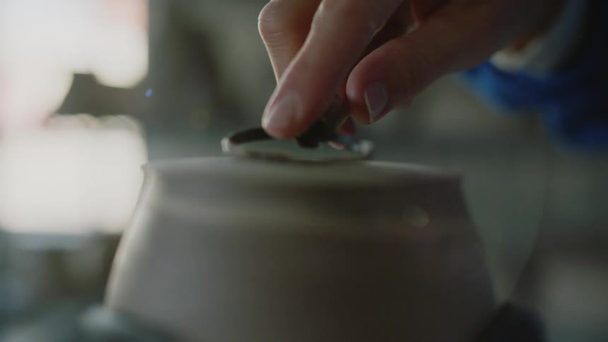 Hands of a sculpture carving a porcelain vase