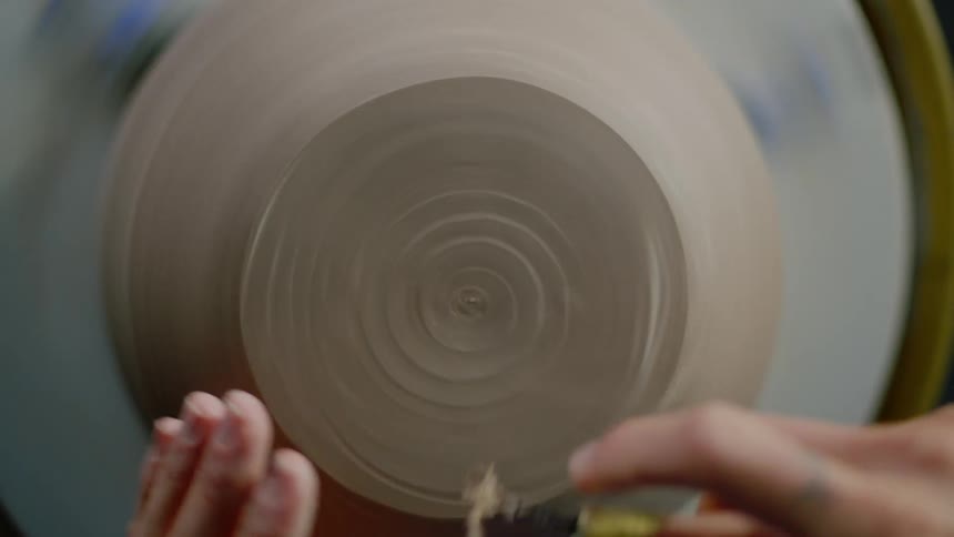 Closeup of a womans hands holding a clay vase
