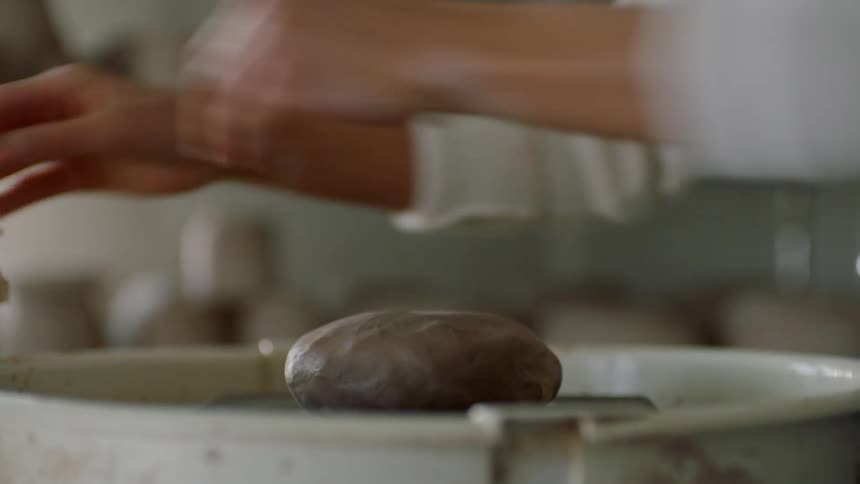 Person put clay on a sculpting wheel
