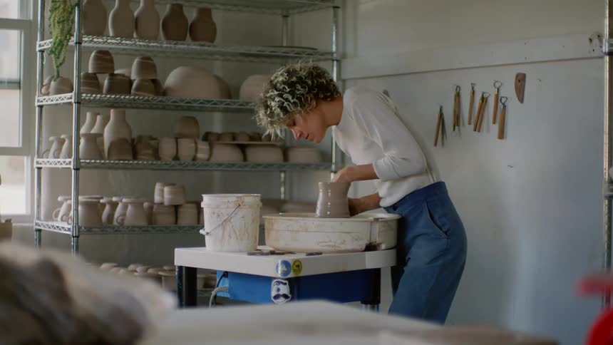 A woman is sculpting with clay