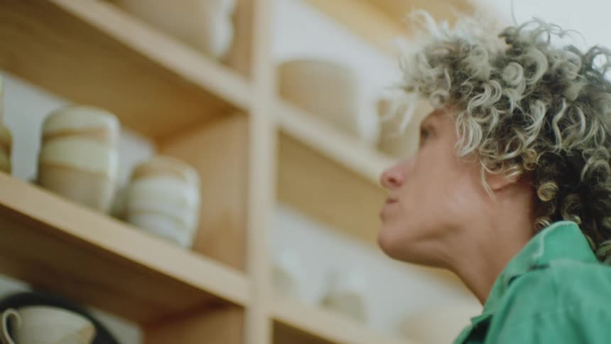 A woman analyzing clay bowls and cups