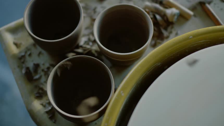 Closeup on a rotating machine dropping clay chips