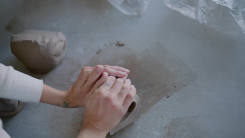 A person modeling clay dough on a table