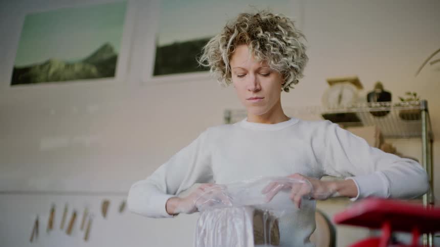 A woman opening a transparent package