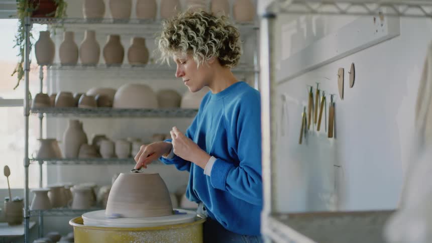 Woman sculpting and making a clay vase