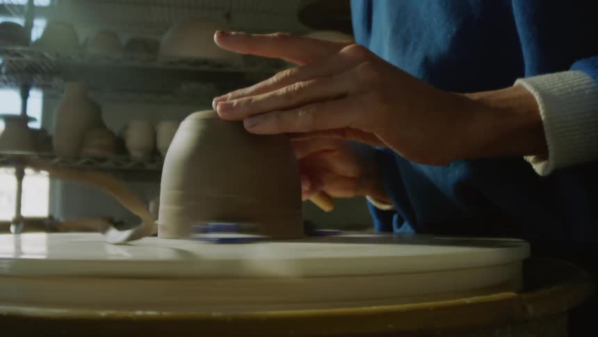 Hands of a woman carving a porcelain vase