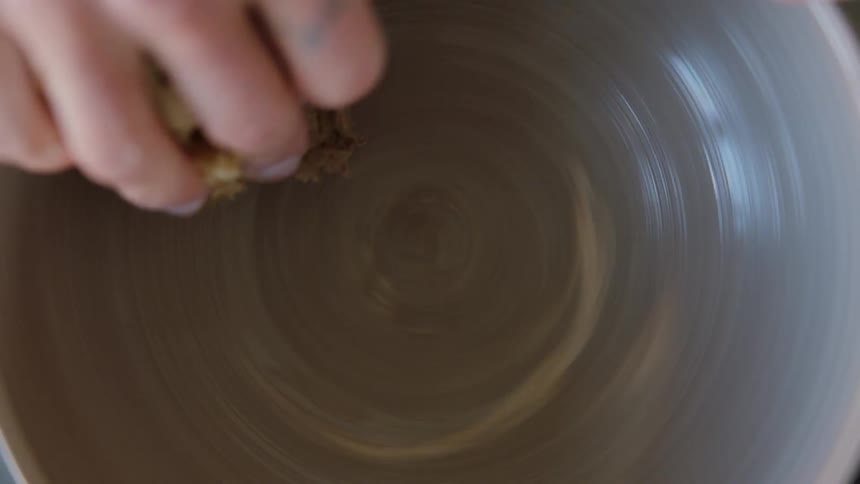 Womans hands molding a clay vase