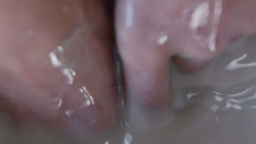 A person dipping their hands into a pan of dirty water