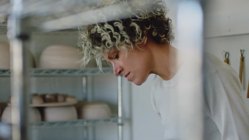 A woman making clay bowls during the day