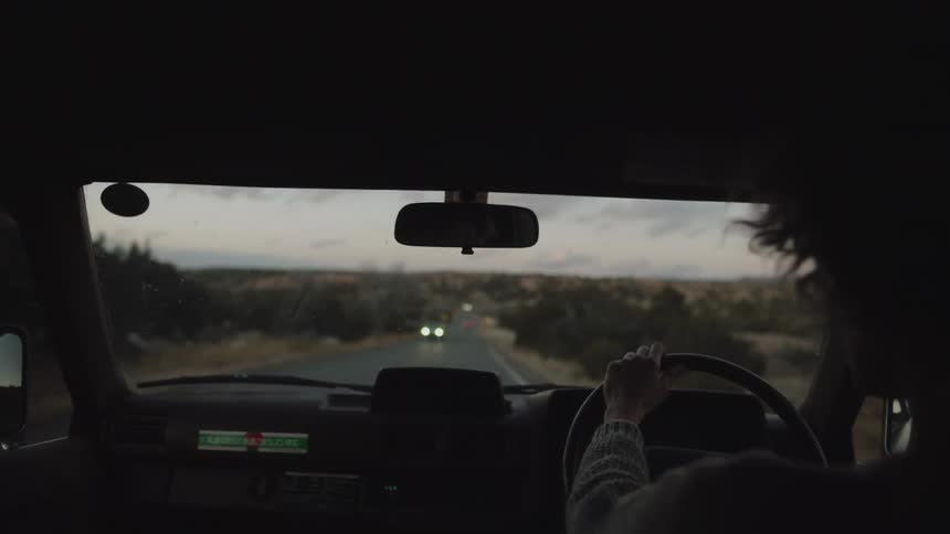 Female driver drives vehicle through the countryside passing other vehicles driving in the opposite direction