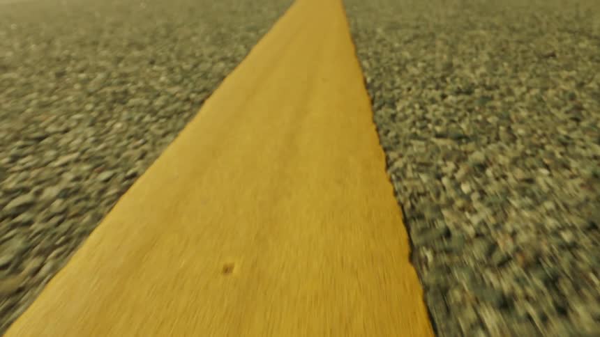 An asphalt ground with a large yellow stripe in the center