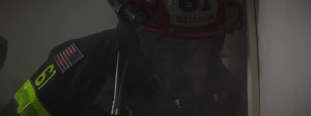 Two firemen trying to break down a door