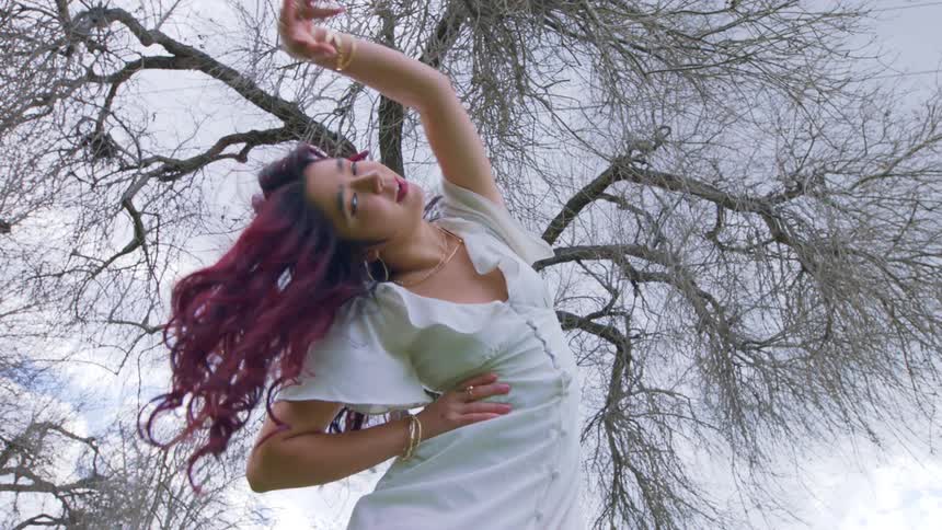Upward view of a redhaired woman dancing