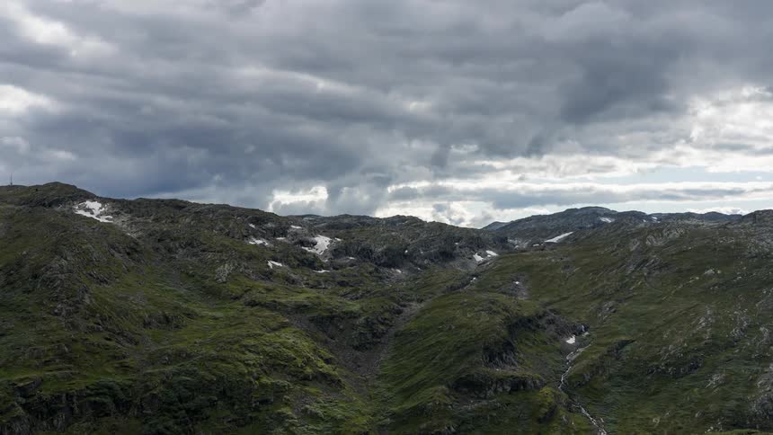 Landscape panoramic of moss and ice covered highland hills with clouds slowly moving in