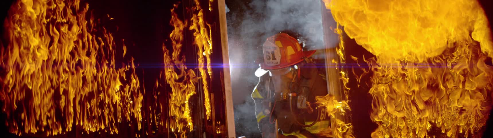 Firefighter opening the door of a residence that is on fire