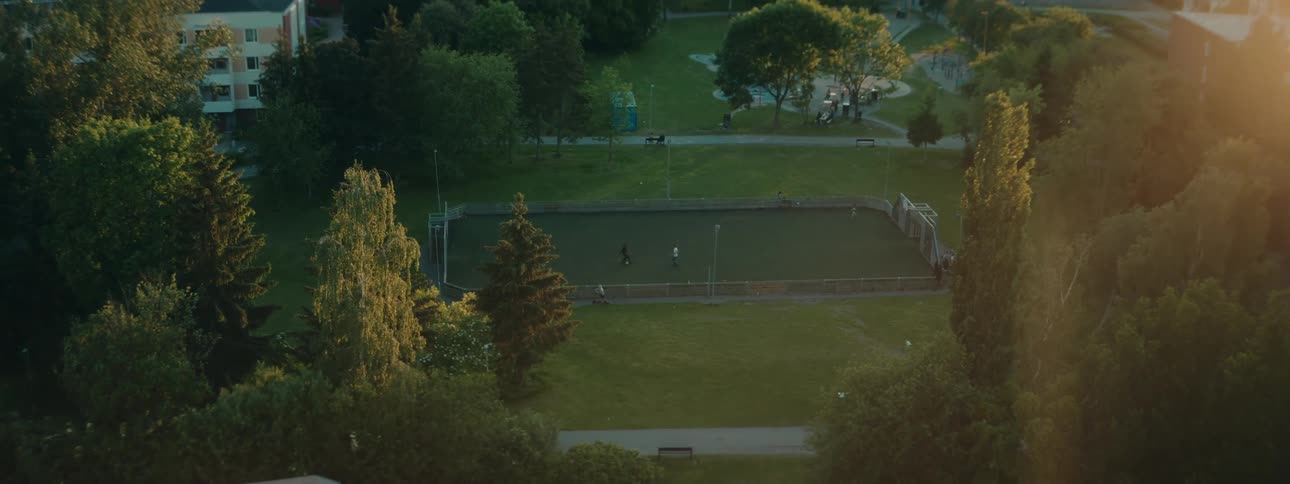 People playing football in a park in a suburban neighborhood