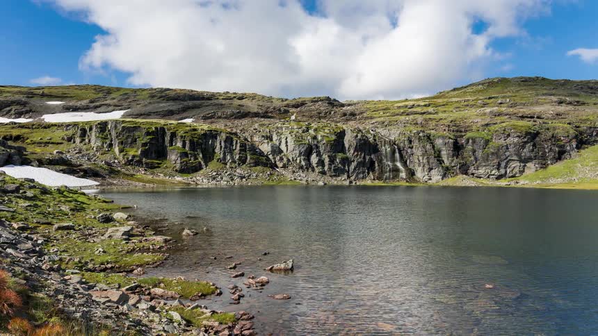 A body of water near mountain cliffs