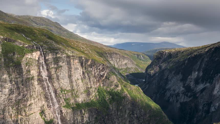 A waterfall at the top of a mountain valley