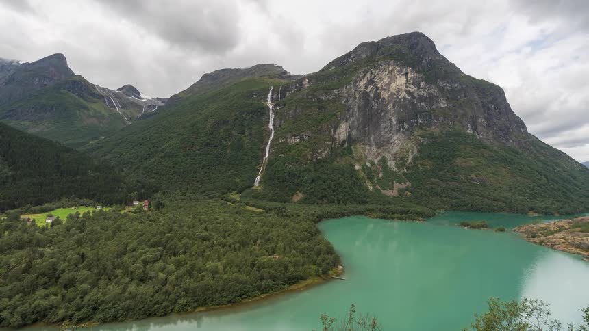 Natural landscape of a turquoise lake surrounded by forested mountain ranges
