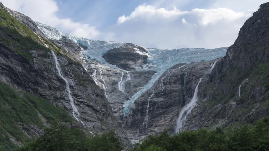 Landscape of a waterfall amidst snowcovered mountains