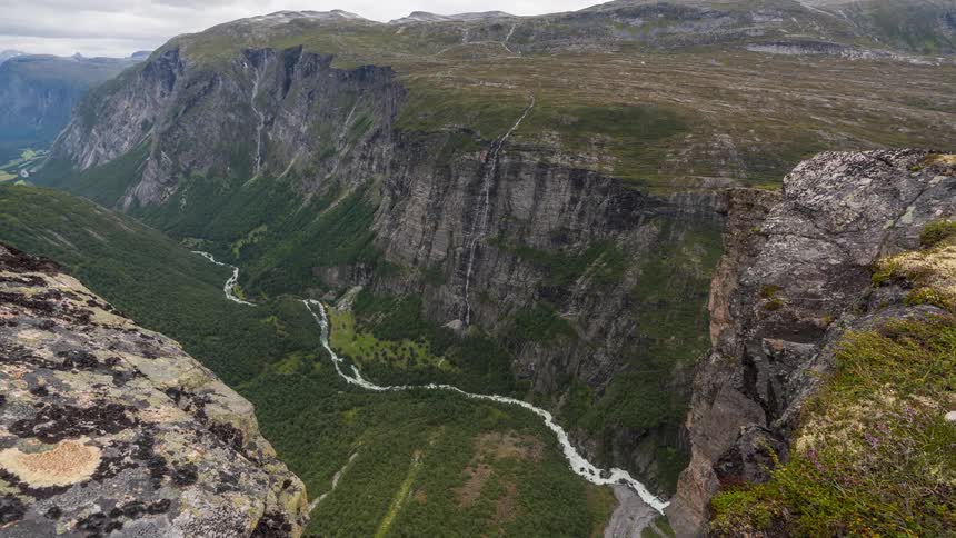 A small stream runs at the base of the mountains