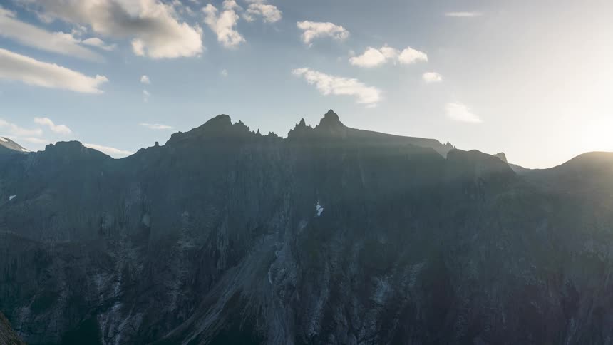 A time lapse of a mountain ranges shows the sun rising in the sky