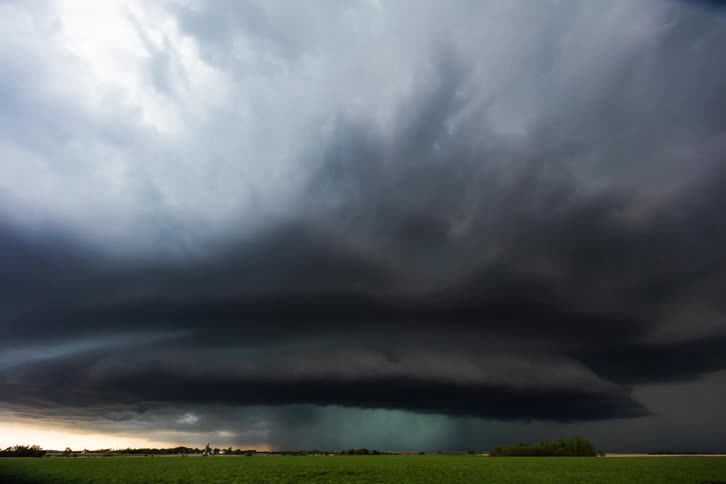 Dark storm clouds move across the sky and pour rain on the land