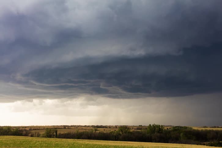 Dark storm clouds move over a rural field