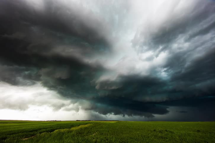 Ominous dark clouds move over a rural area as a super cell pours rain over the land