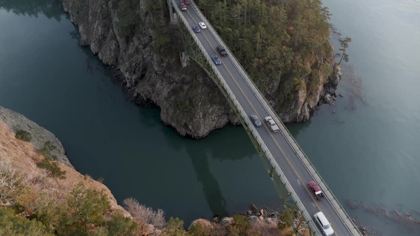 Birds eye view of traffic crossing a narrow bridge over a deep gorge