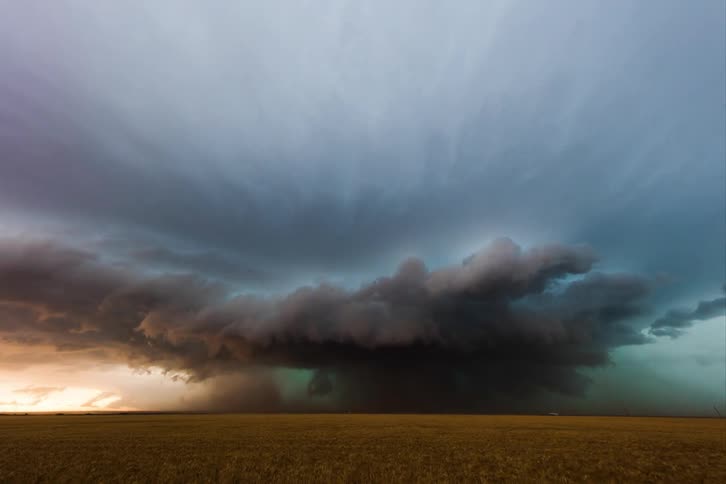 A storm lighting up the meadow during sunset