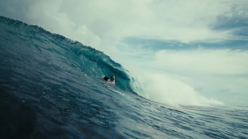 A surfer photographing a wave with a camera