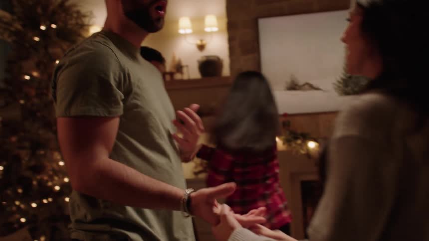 Family indoors during the festive season playfully dancing together