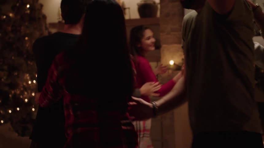 A family with several people are all holding each others waist and spinning in a circle and everyone is happy