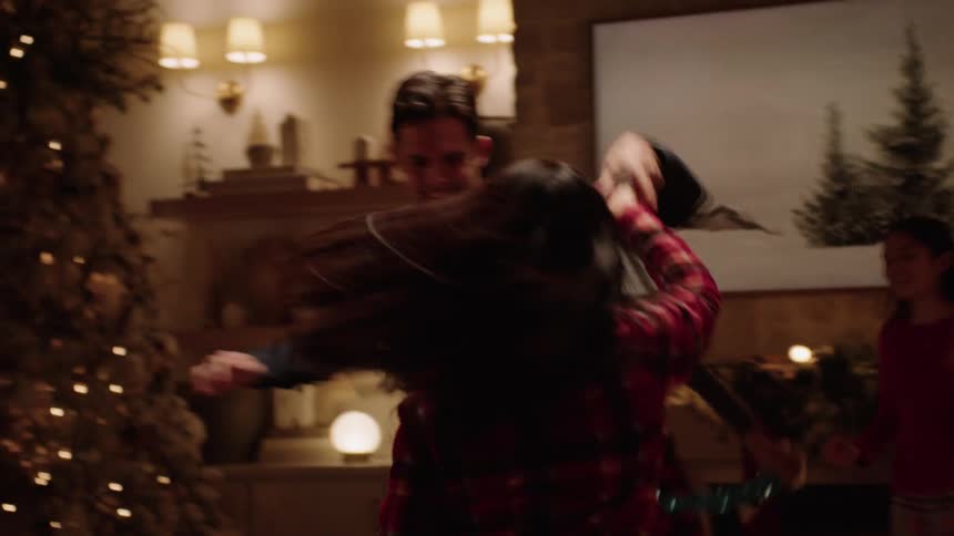 A couple dancing in the living room during christmas
