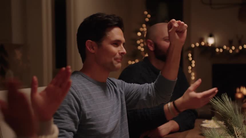 Family have fun eating popcorn and unwrapping christmas gifts