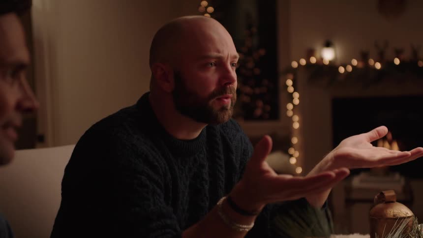 Portrait of two men talking while sitting at the table at night