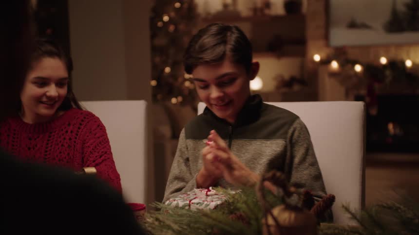 A boy wrapping a gift while talking to someone
