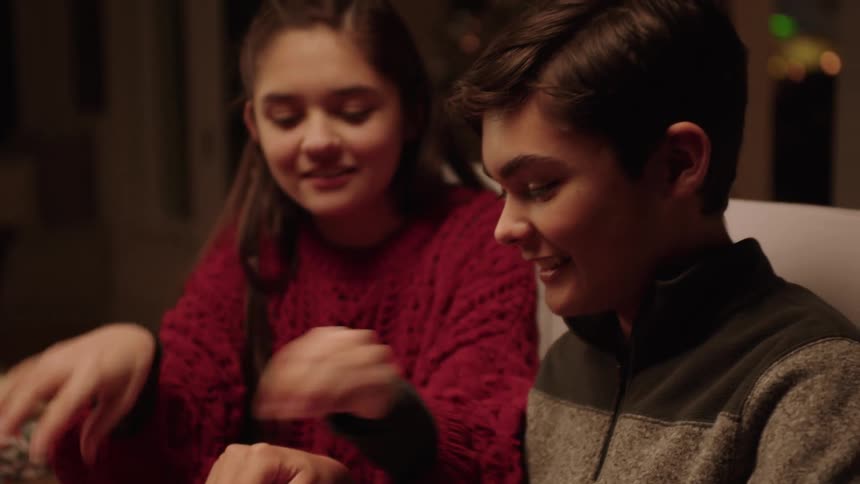 Siblings wrapping a christmas present