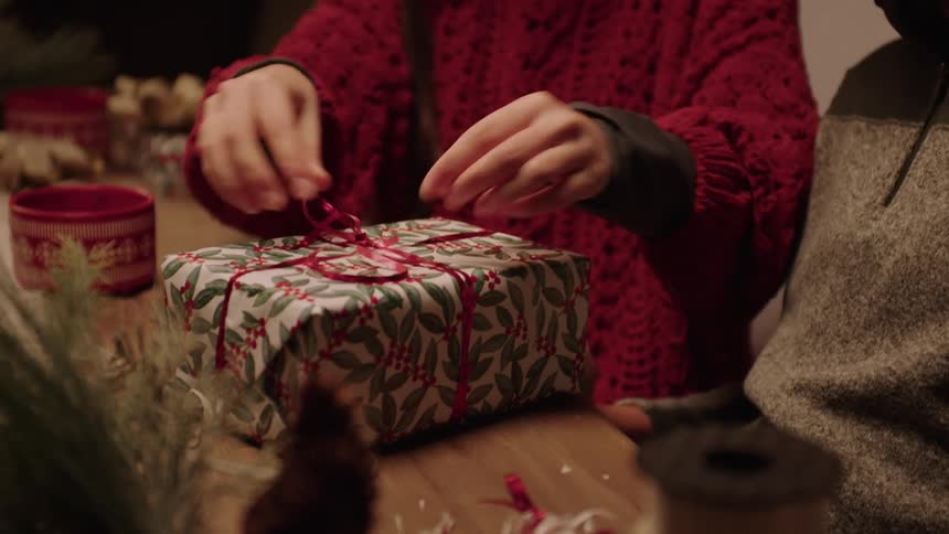 Siblings hug and open a christmas present